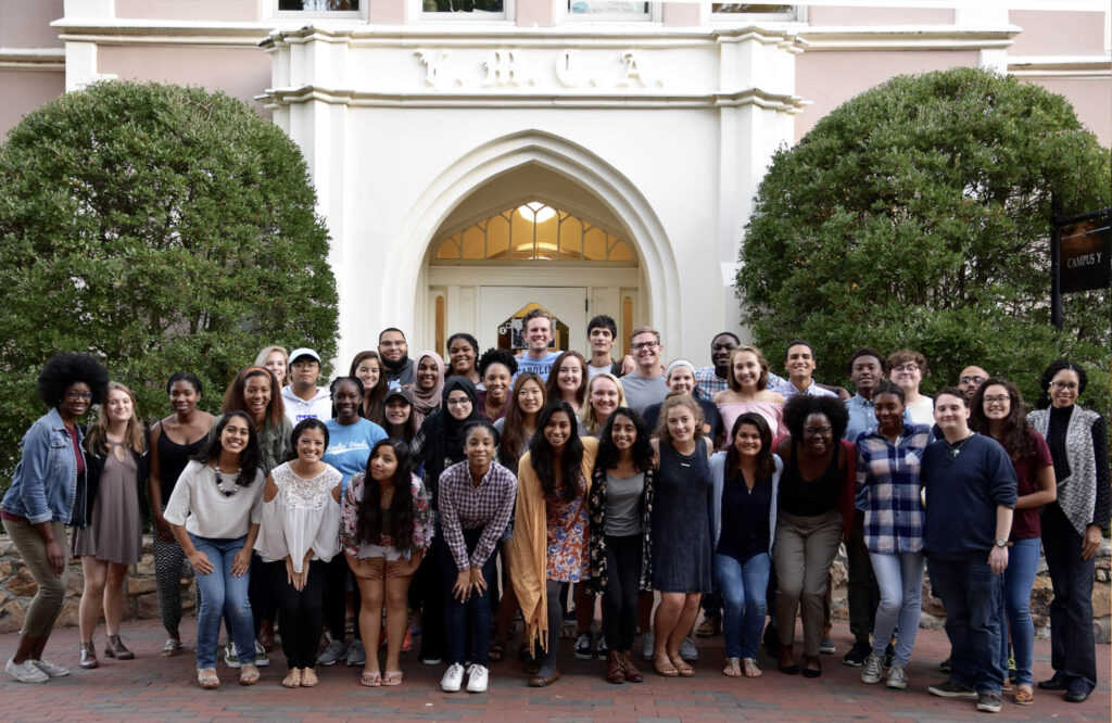 A large diverse group of students pose in front of the Campus Y building.